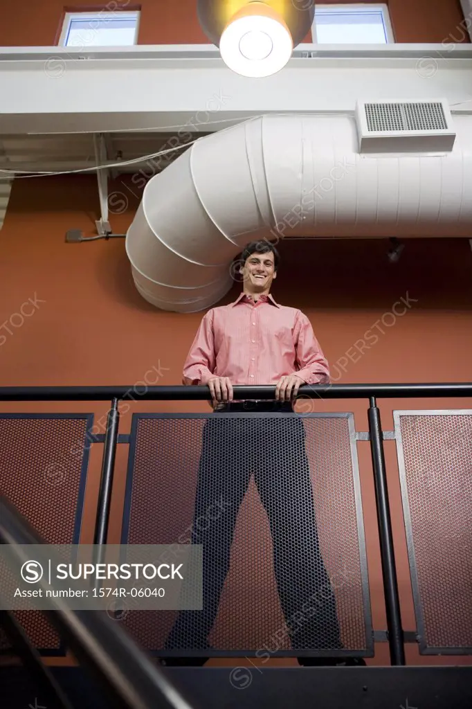 Low angle view of a businessman against a railing