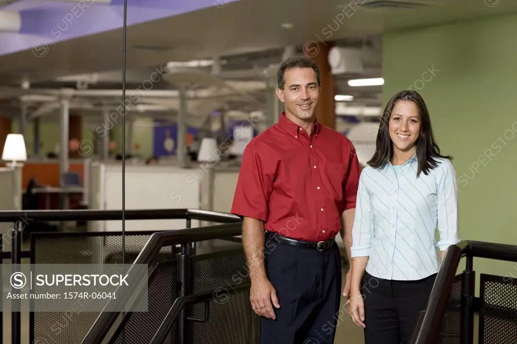Portrait of a businesswoman and a businessman standing on stairs