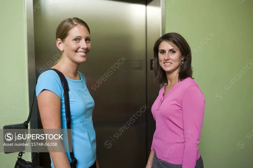 Portrait of two businesswomen standing near an elevator