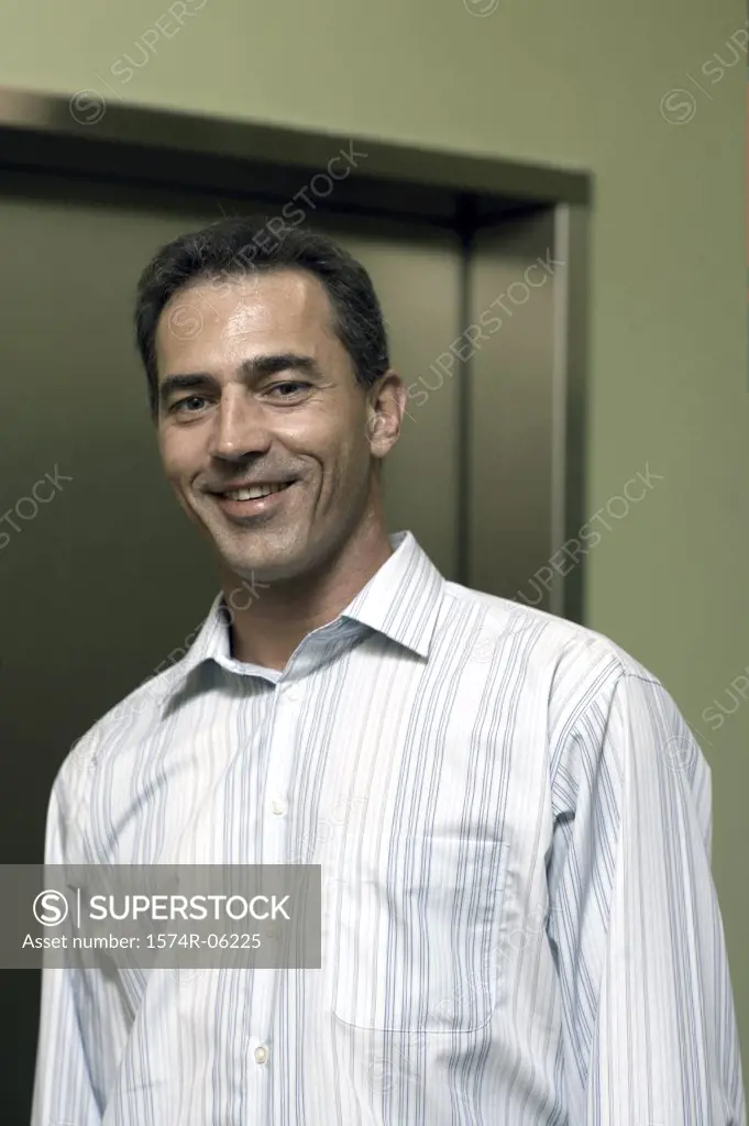 Portrait of a businessman standing near an elevator