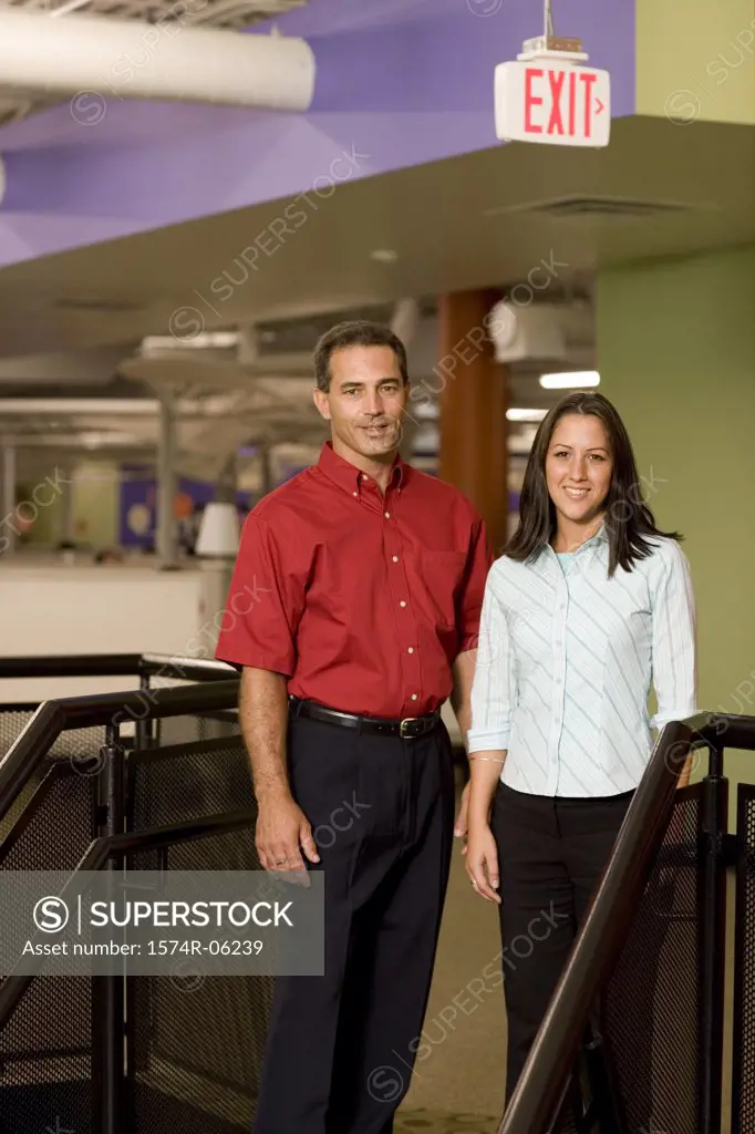 Portrait of a businessman and a businesswoman standing on stairs