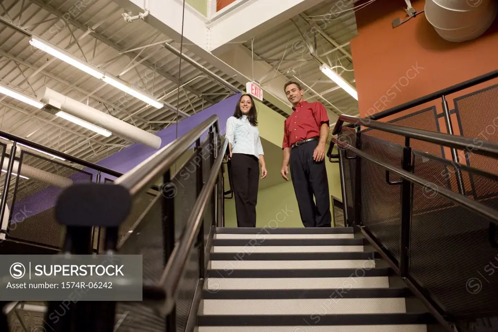 Low angle view of a businessman and a businesswoman standing on stairs