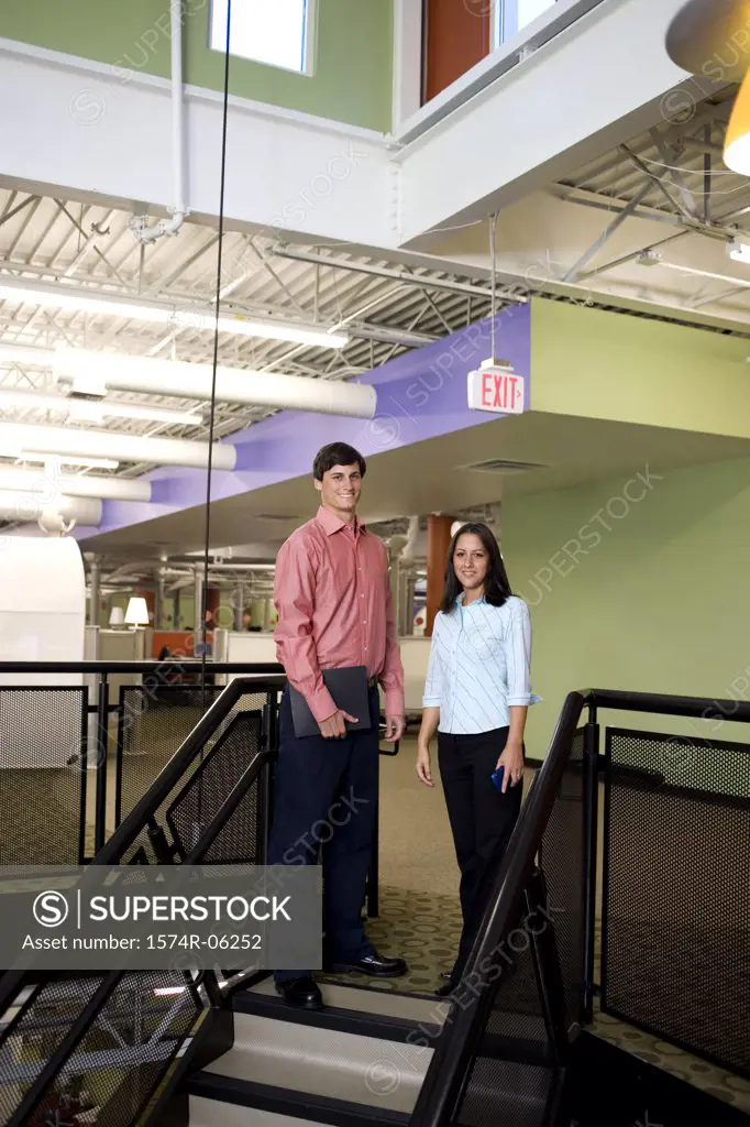 Portrait of a businessman and a businesswoman standing on stairs