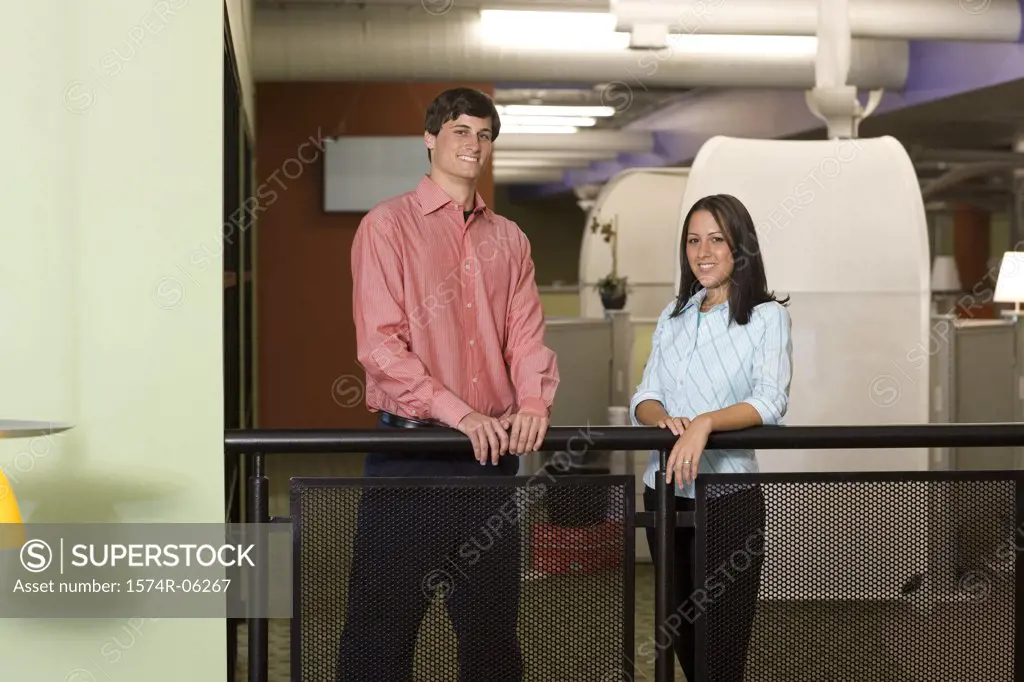 Portrait of a businessman and a businesswoman standing against a railing