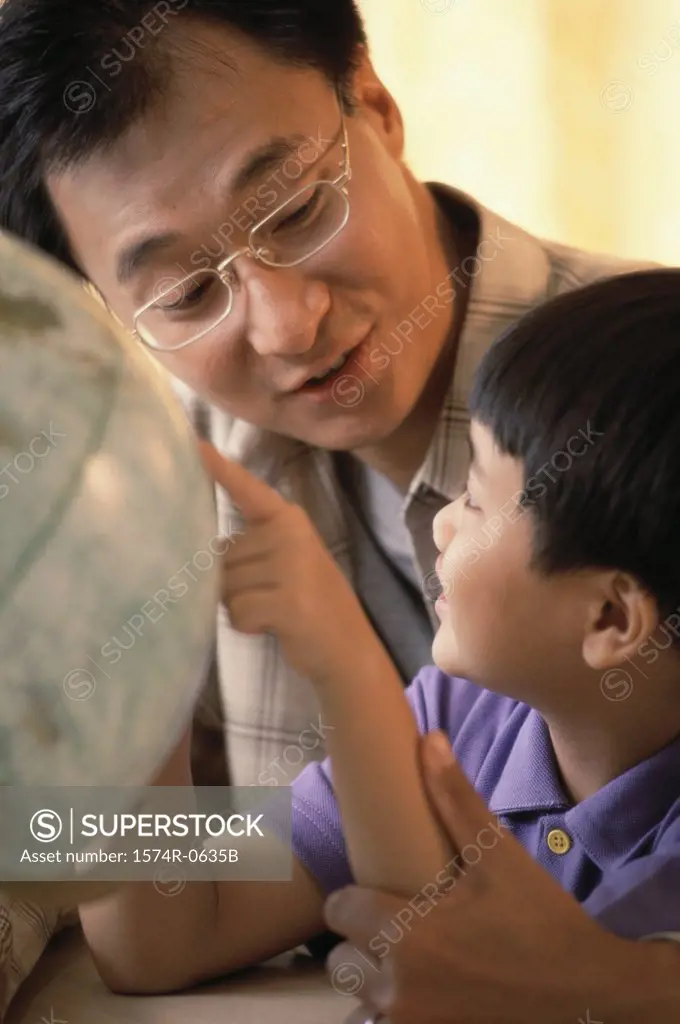 Father and son looking at a globe