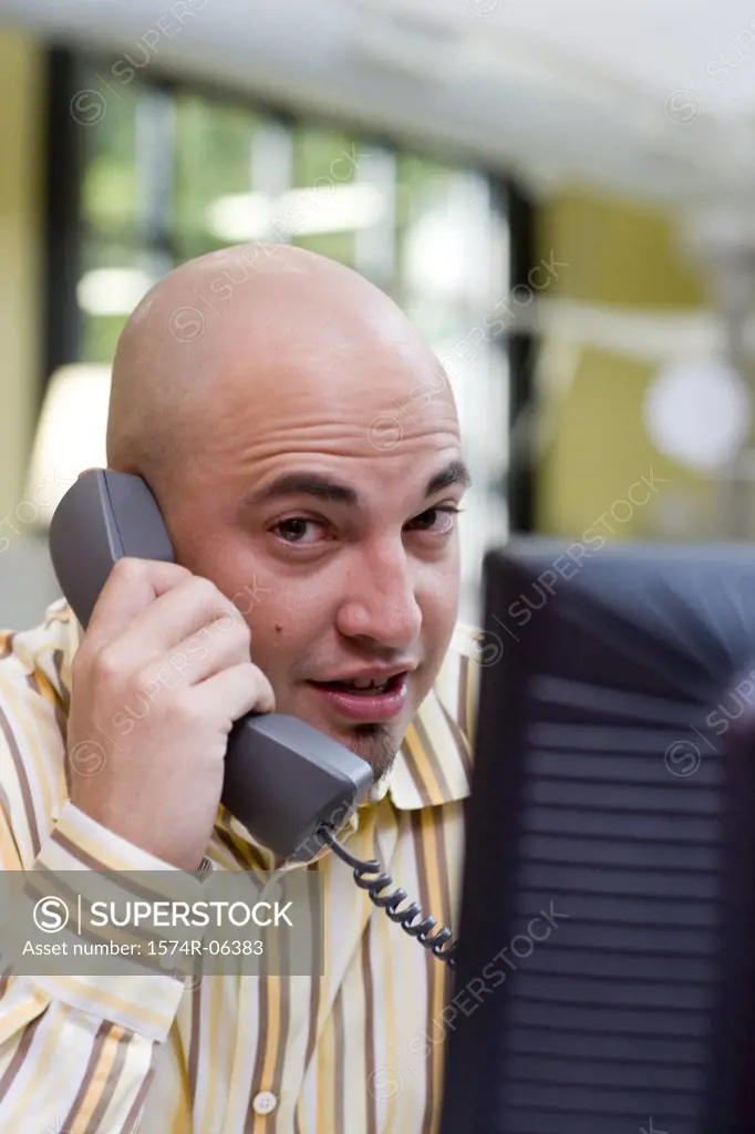 Portrait of a businessman talking on a telephone in an office