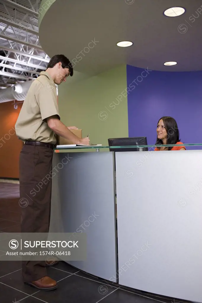 Side profile of a delivery man writing on a paper at a reception desk