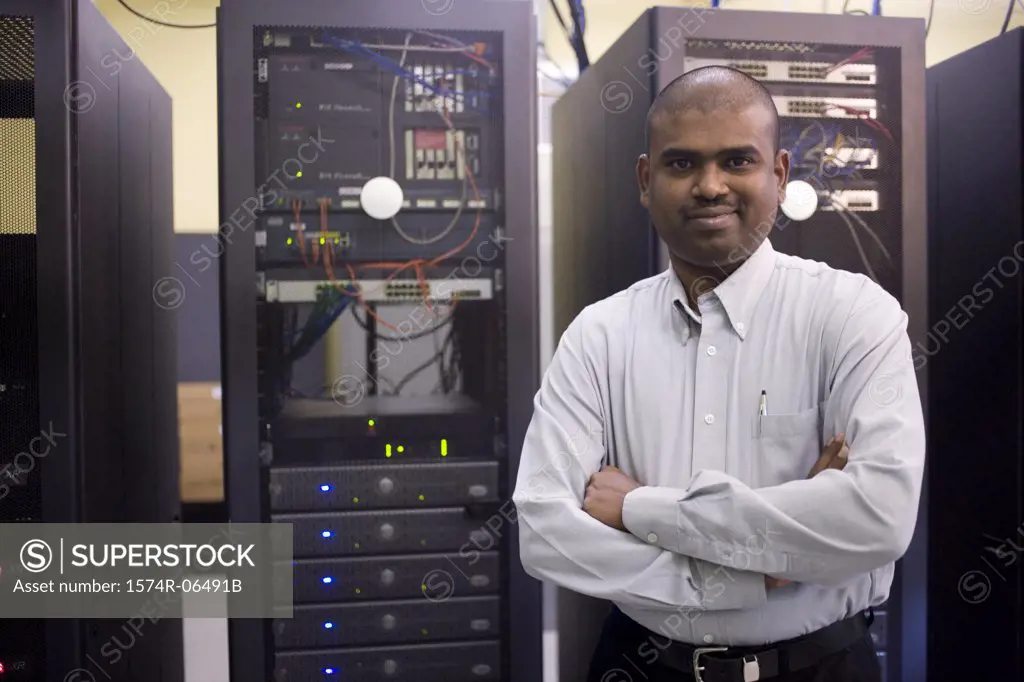 Portrait of a technician standing in front of network servers