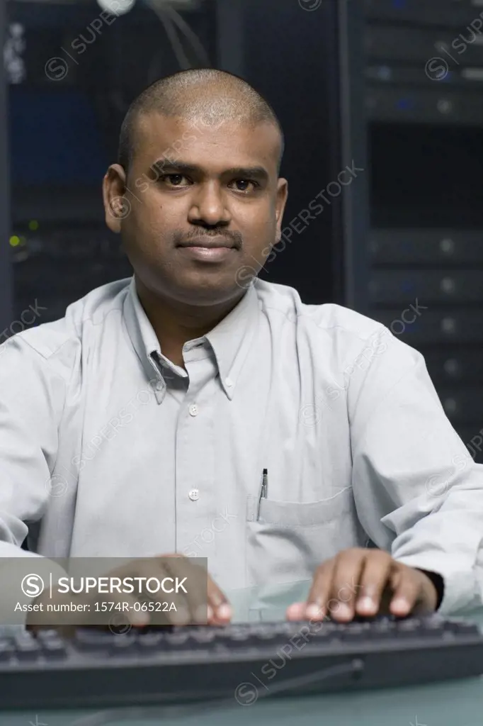 Portrait of a technician using a computer in a server room