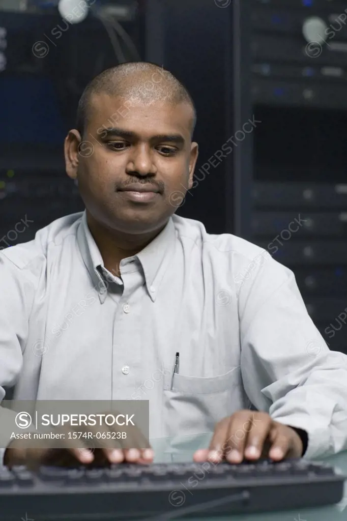 Technician using a computer in a server room