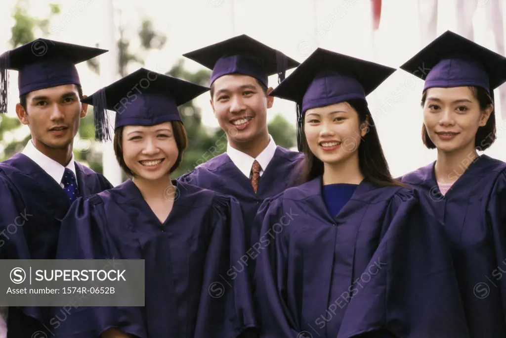 Portrait of three female graduates and two male graduates smiling