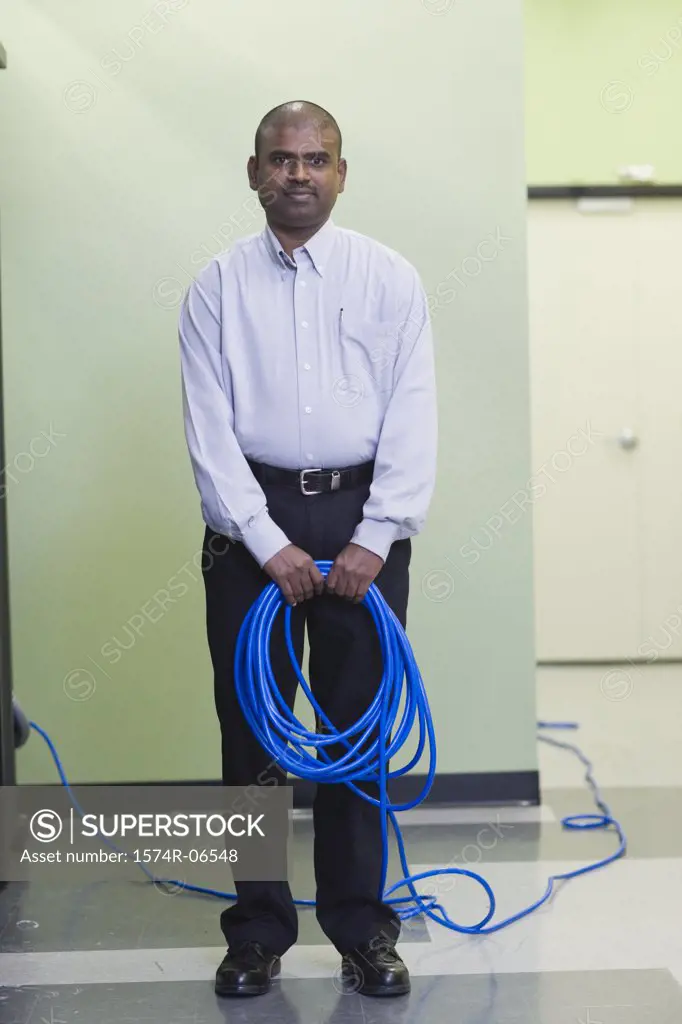 Portrait of a technician holding computer cables