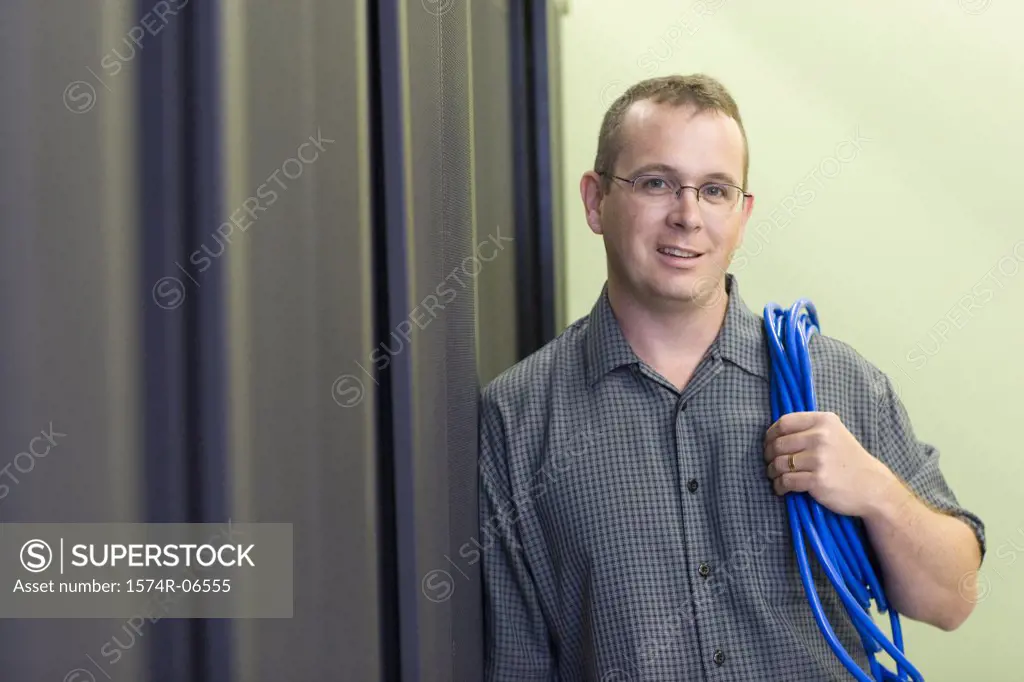 Portrait of a technician carrying computer cables on his shoulder