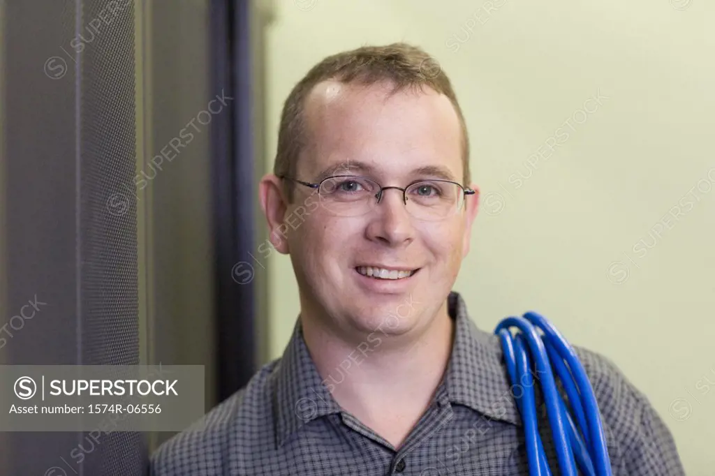 Portrait of a technician carrying computer cables on his shoulder