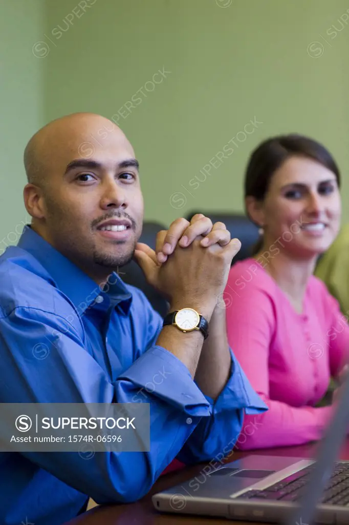 Portrait of a businessman and a businesswoman smiling in an office