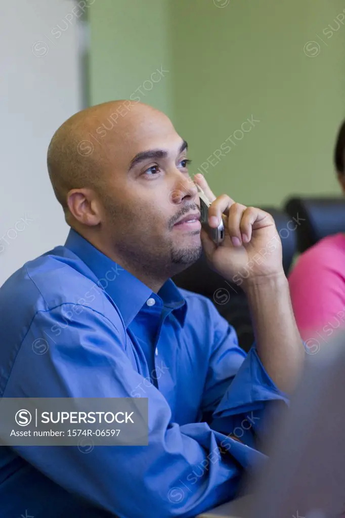Side profile of a businessman using a mobile phone in an office
