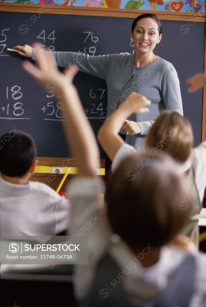 Teacher pointing to a chalkboard in class