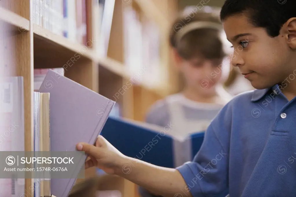Boy taking a book from a shelf