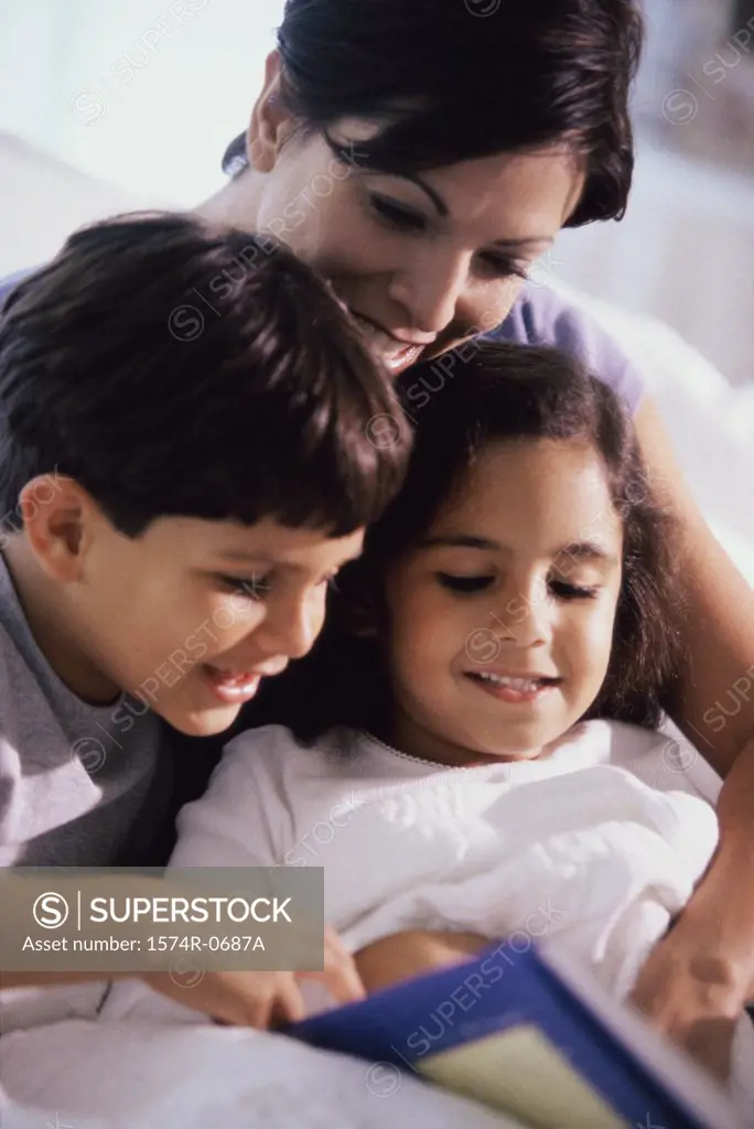 Mother and her two children reading a book