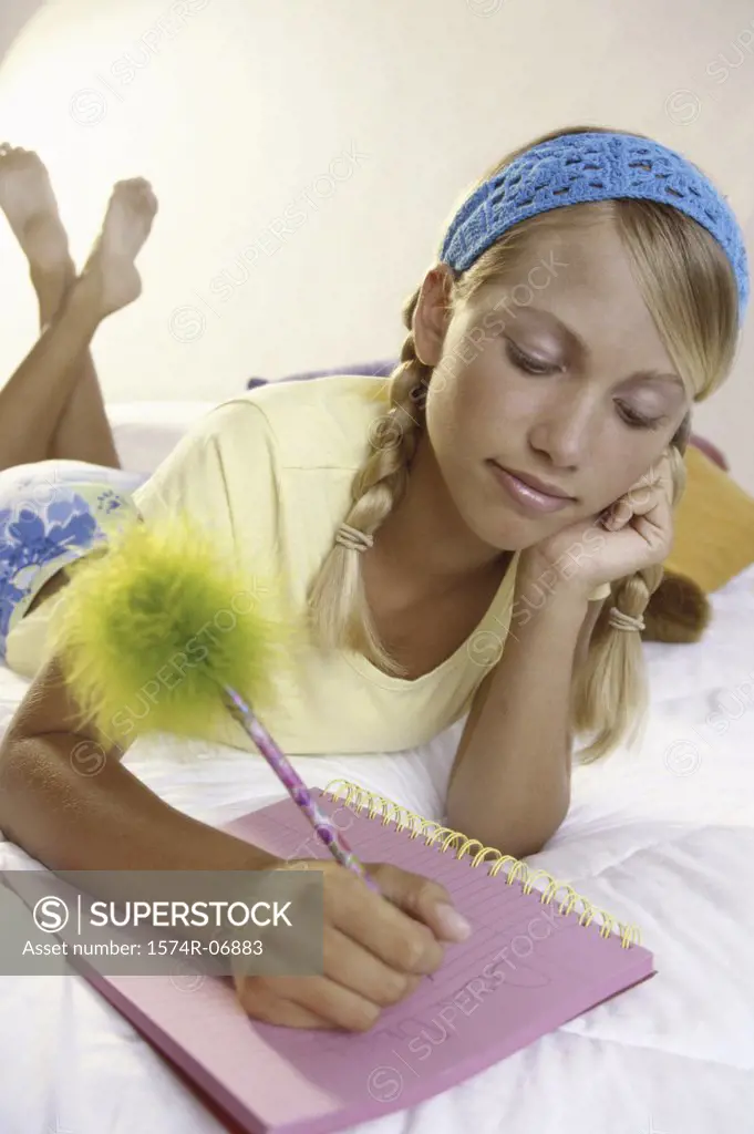 Teenage girl writing in a notebook