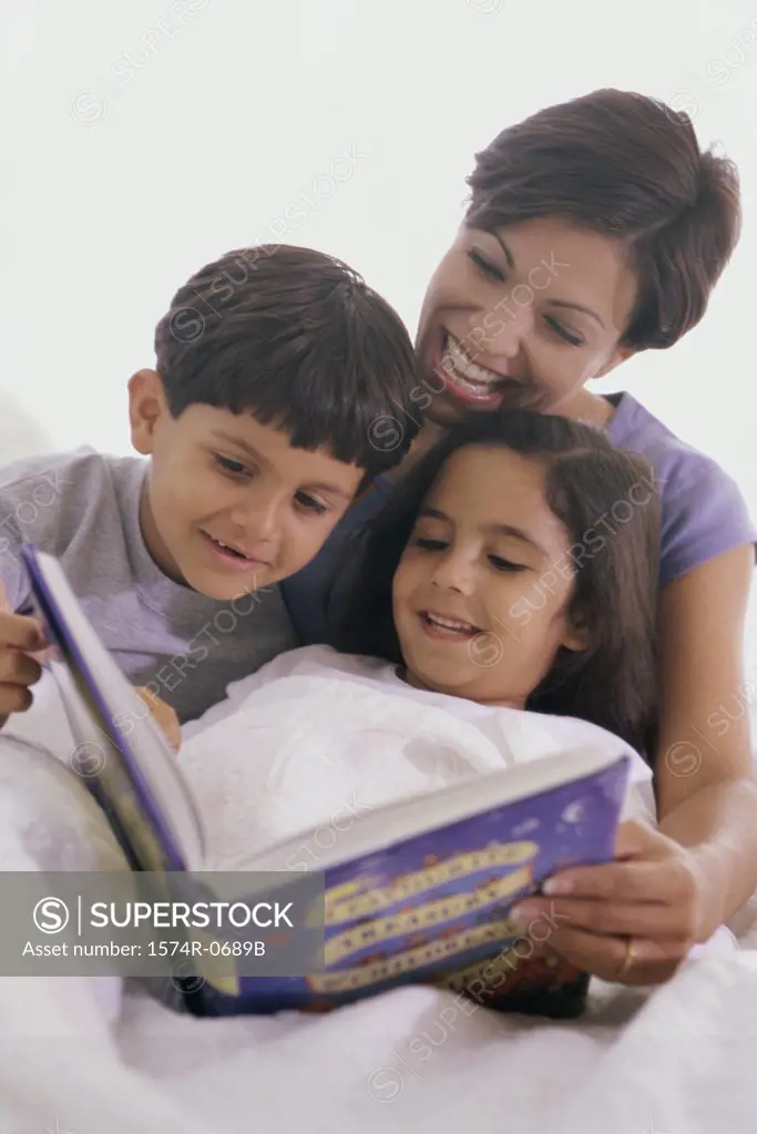Mother and her two children reading a book