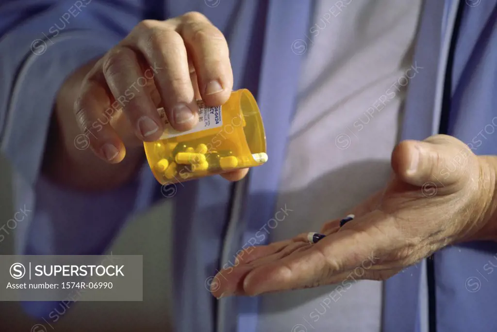 Close-up of a person holding a bottle of pills