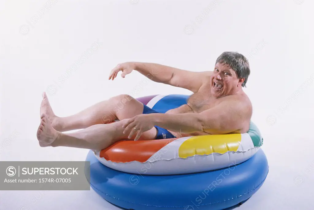 Portrait of a mid adult man sitting on an inflatable ring