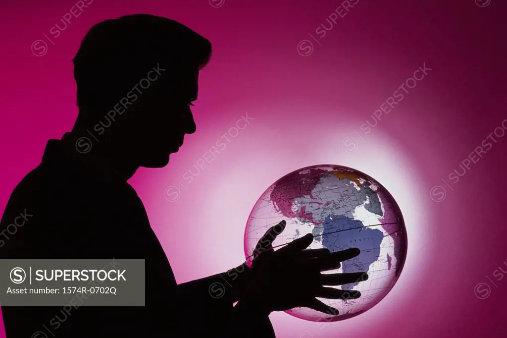 Side profile of a businessman holding a globe
