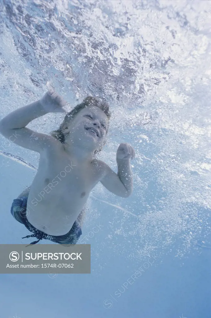 Boy swimming underwater in a swimming pool