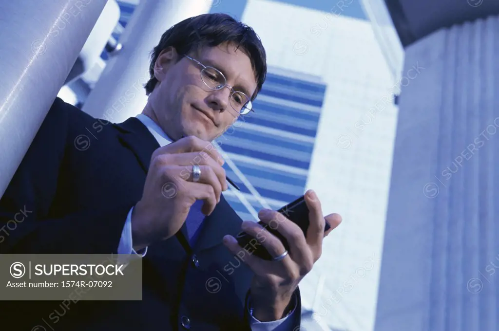 Low angle view of a businessman using a hand held device