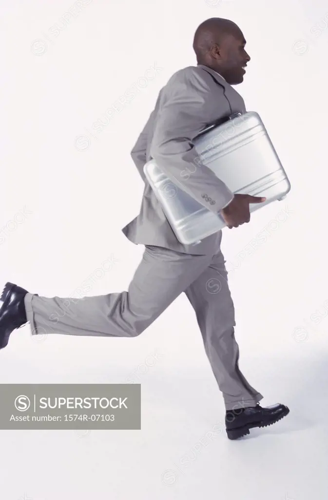 Side profile of a businessman running with a briefcase
