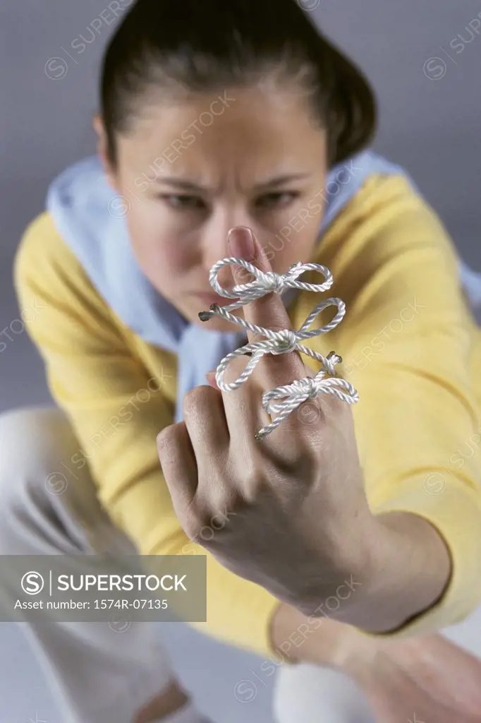 Woman sitting with string tied around her index finger