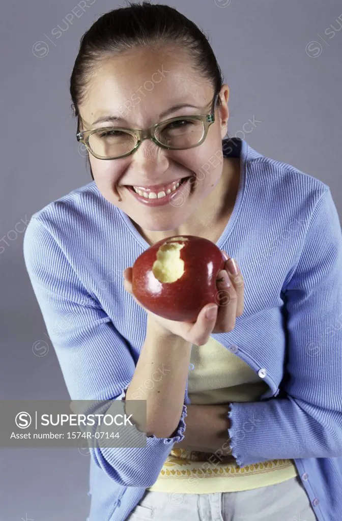 Portrait of a teenage girl holding an apple smiling
