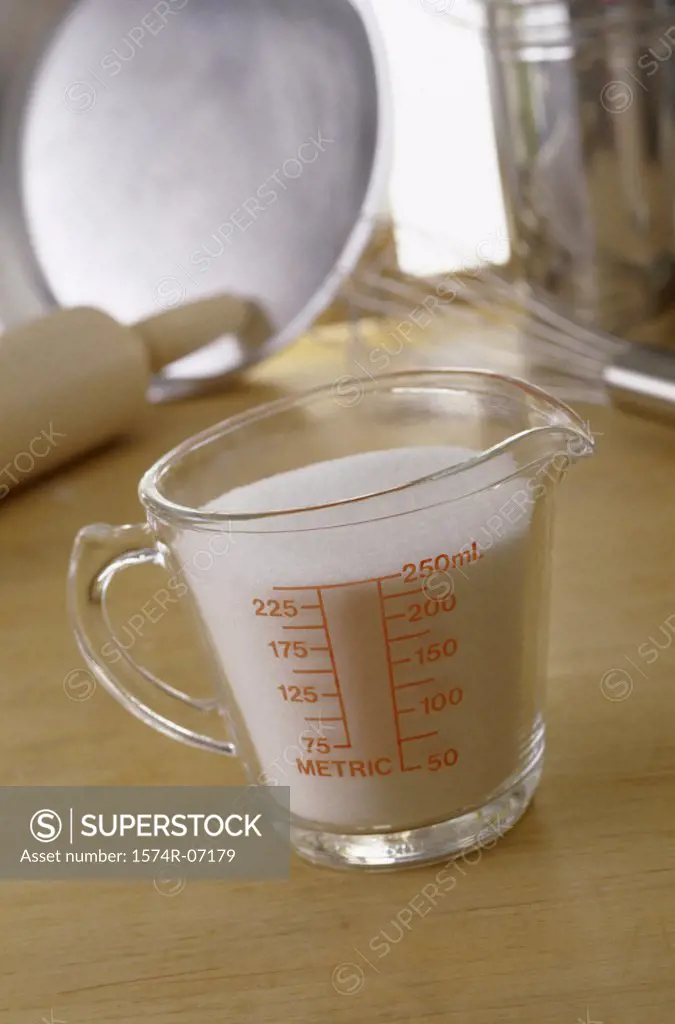 Measuring cup filled with sugar