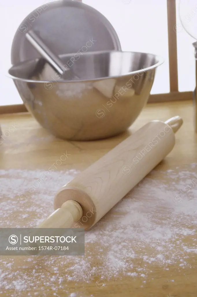 Close-up of a rolling pin near a mixing bowl