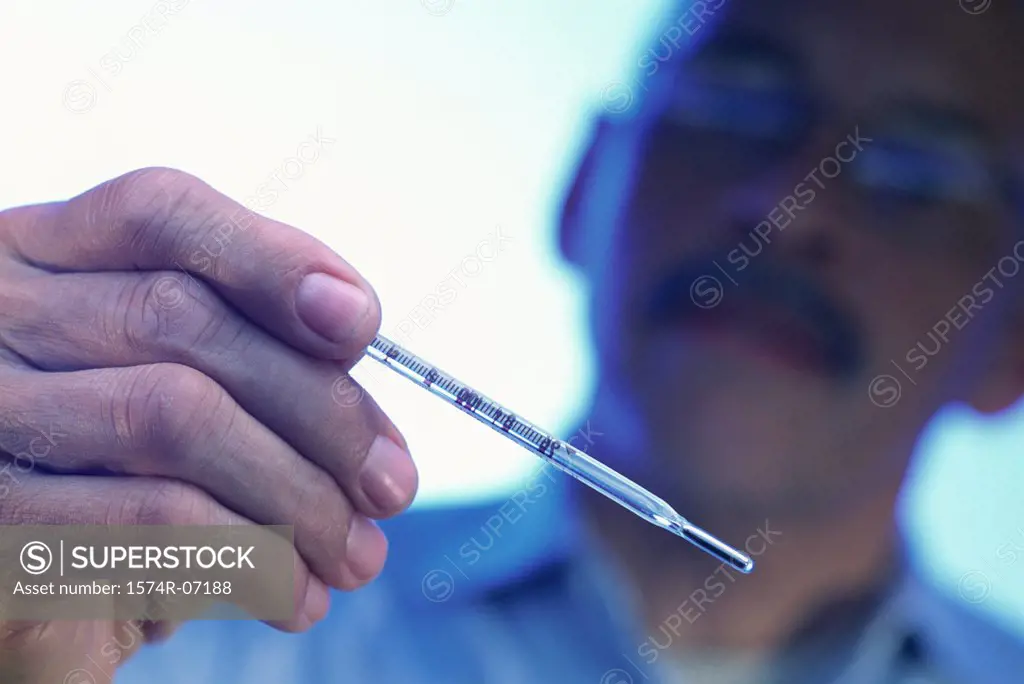 Mature man holding a thermometer
