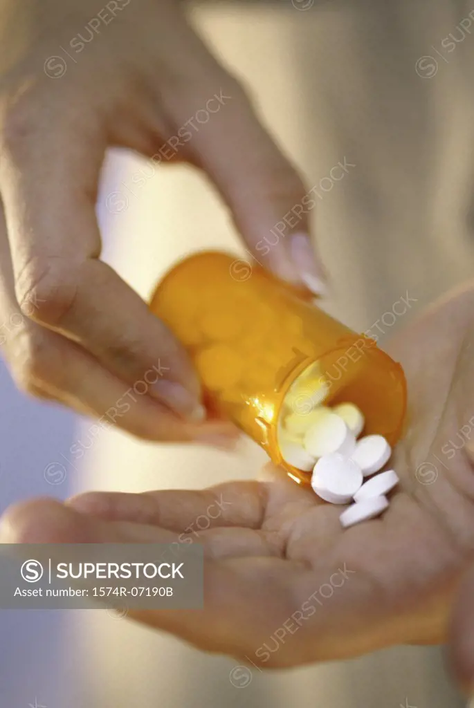 Person holding a vial of tablets