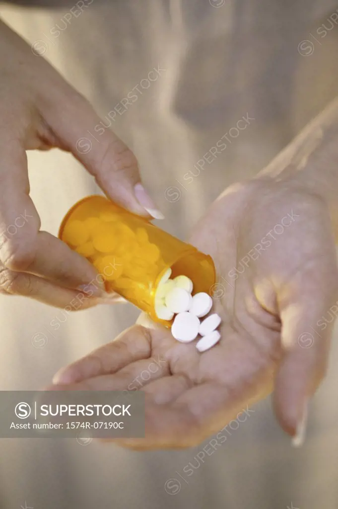 Person holding a vial of tablets