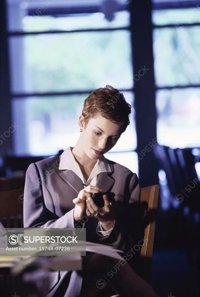 Businesswoman sitting in a restaurant using a hand held device
