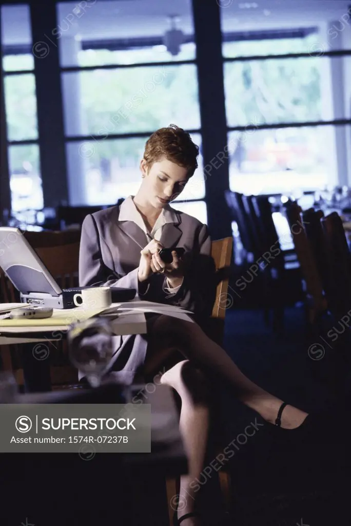 Woman sitting in a restaurant using a hand held device
