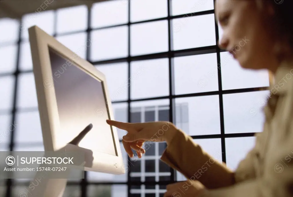 Low angle view of a businesswoman pointing to a computer monitor