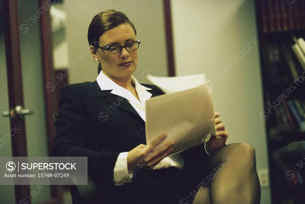 Portrait of a businesswoman sitting on a chair reading papers