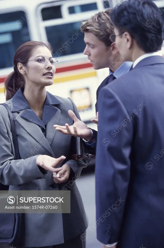 Two businessmen and a businesswoman talking