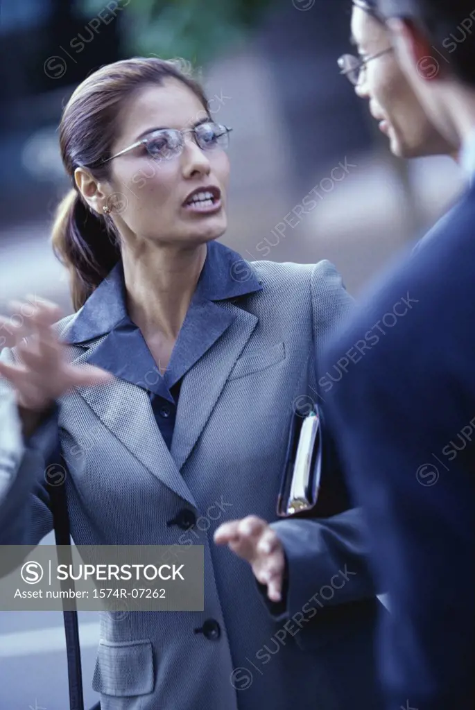 Close-up of two businessmen and a businesswoman talking