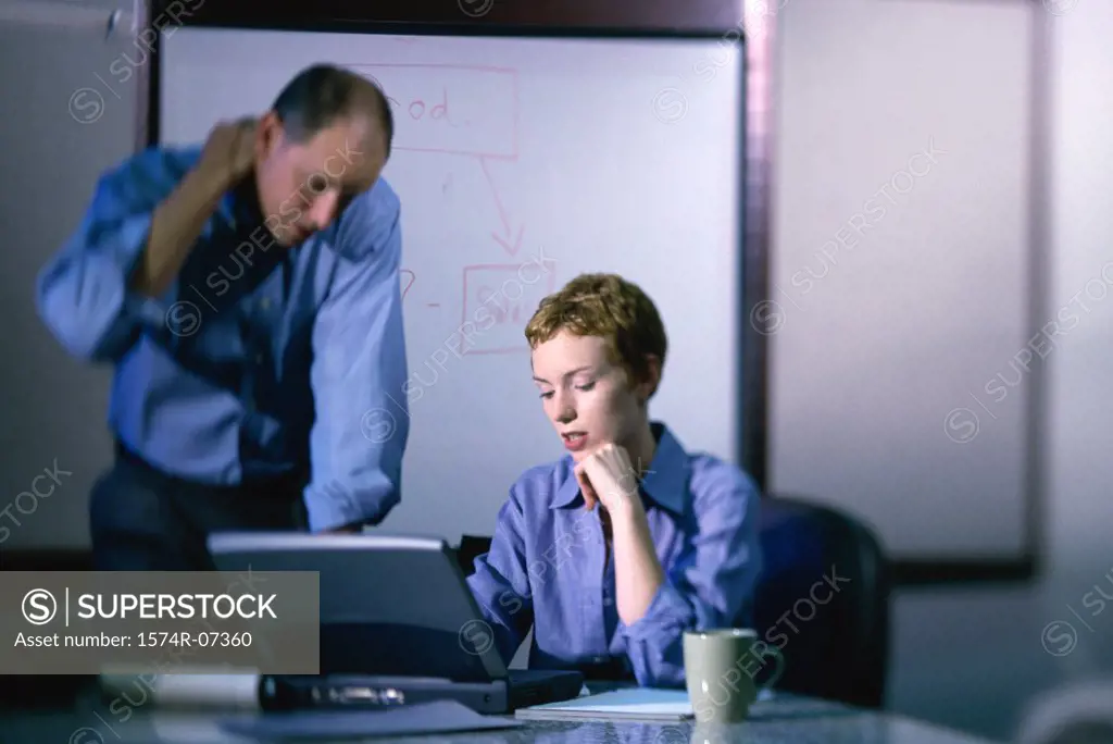Businessman and a businesswoman working on a laptop