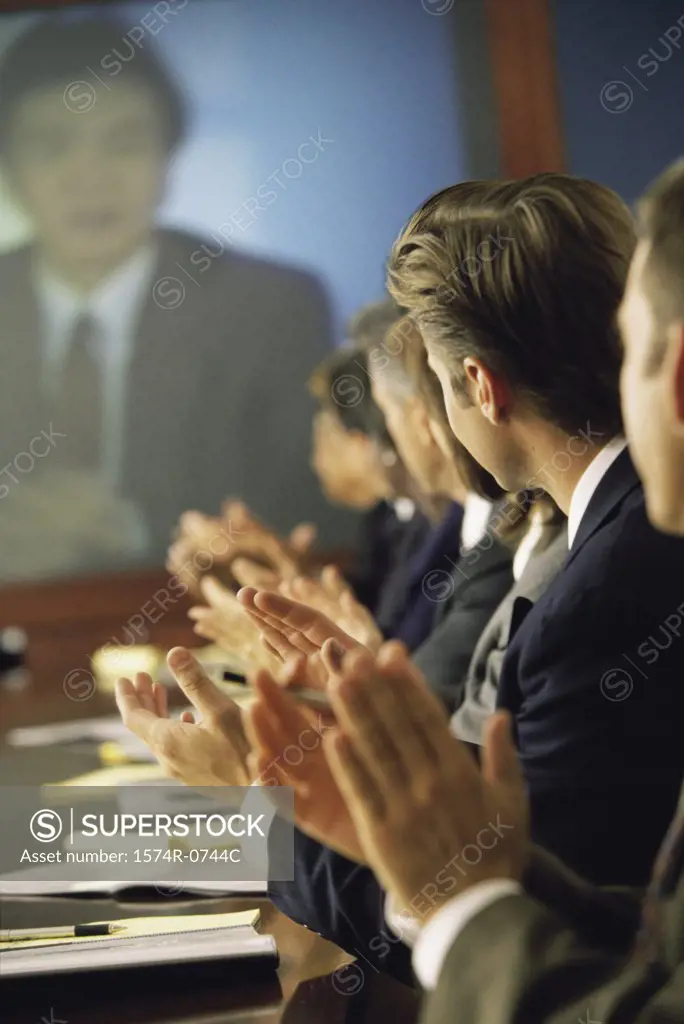 Business executives applauding in a meeting