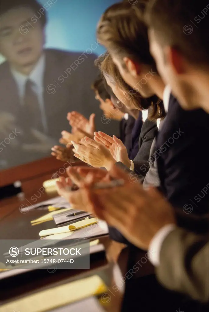Group of business executives applauding at a meeting