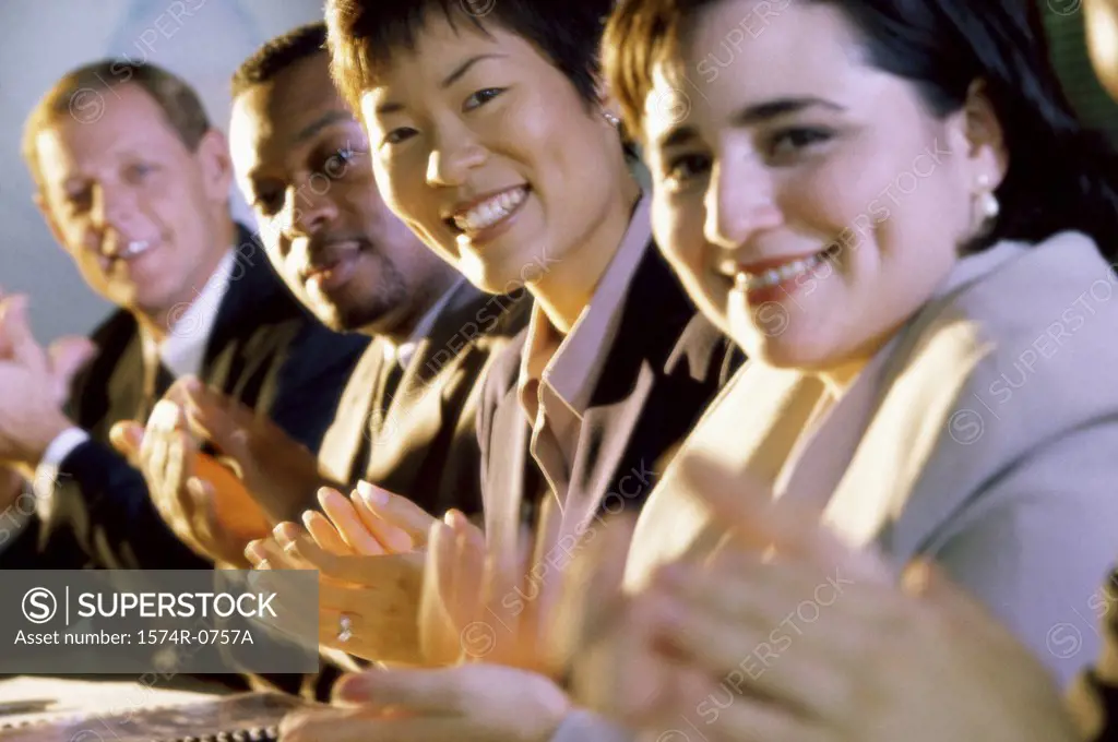 Portrait of business executives clapping