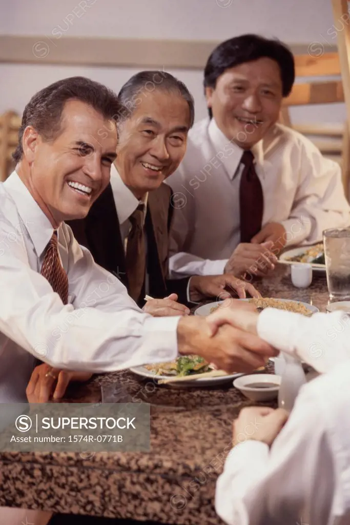 Three business executives seated at a restaurant