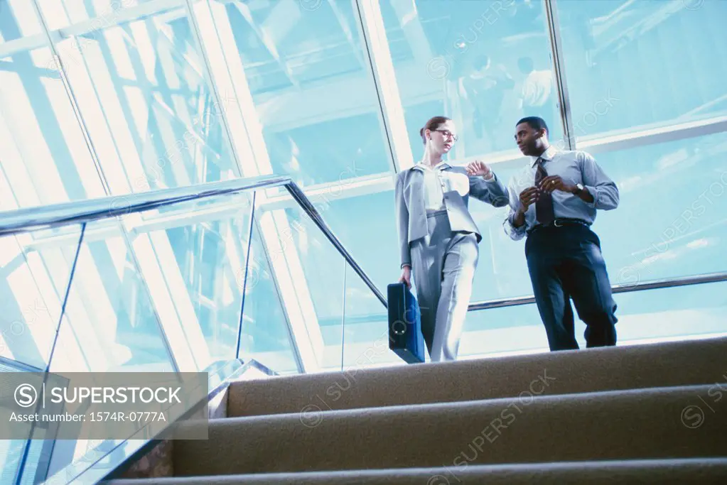 Low angle view of two business executives standing at the top of stairs